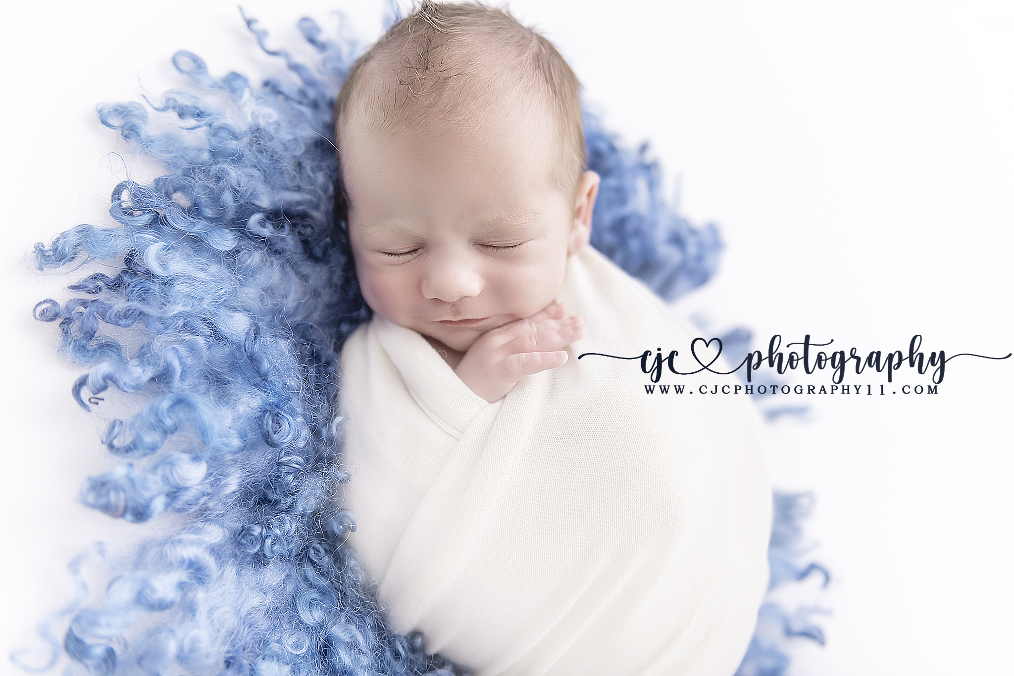 smiling infant boy on blue rug
