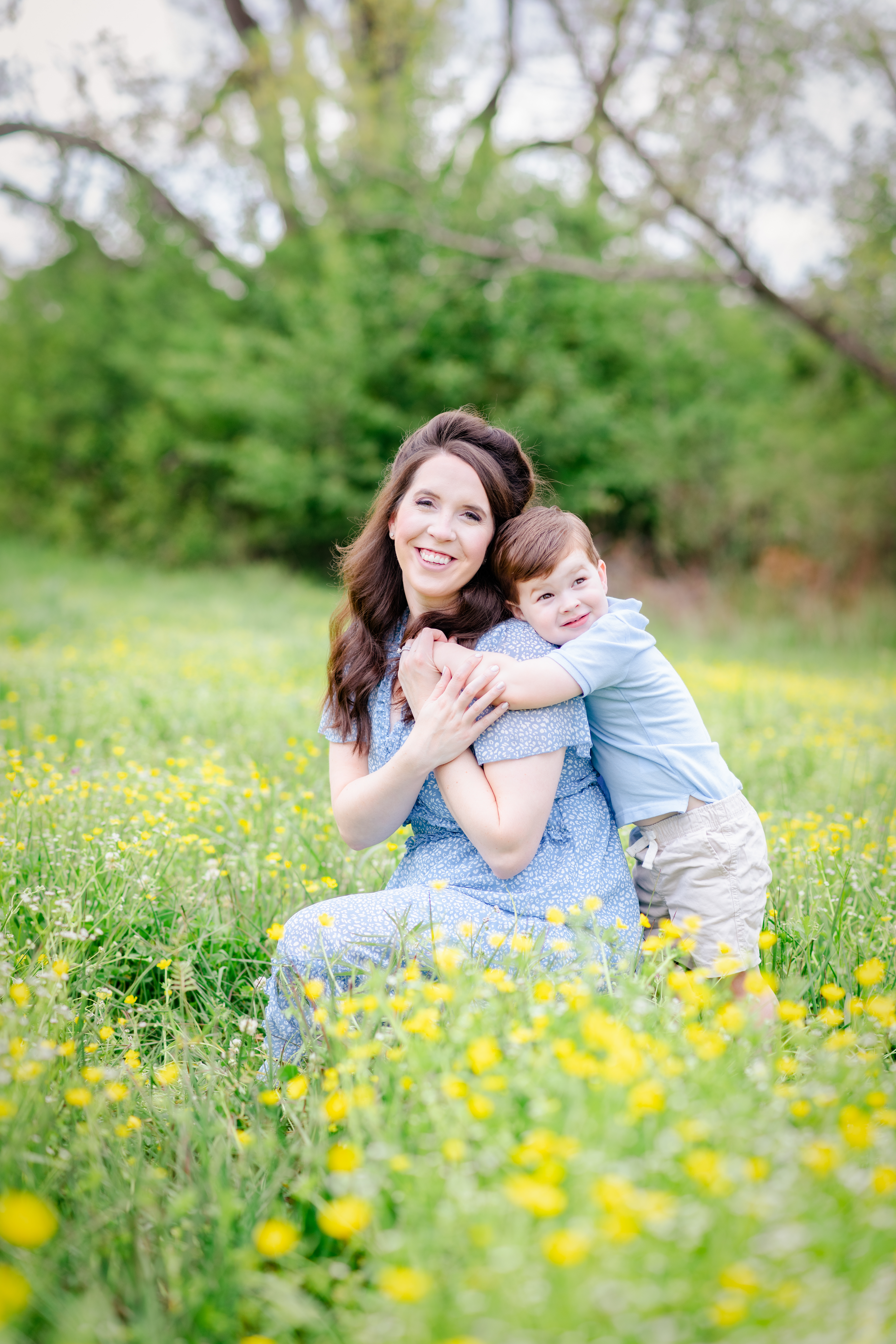 mother posing with son in yellow wildflowers